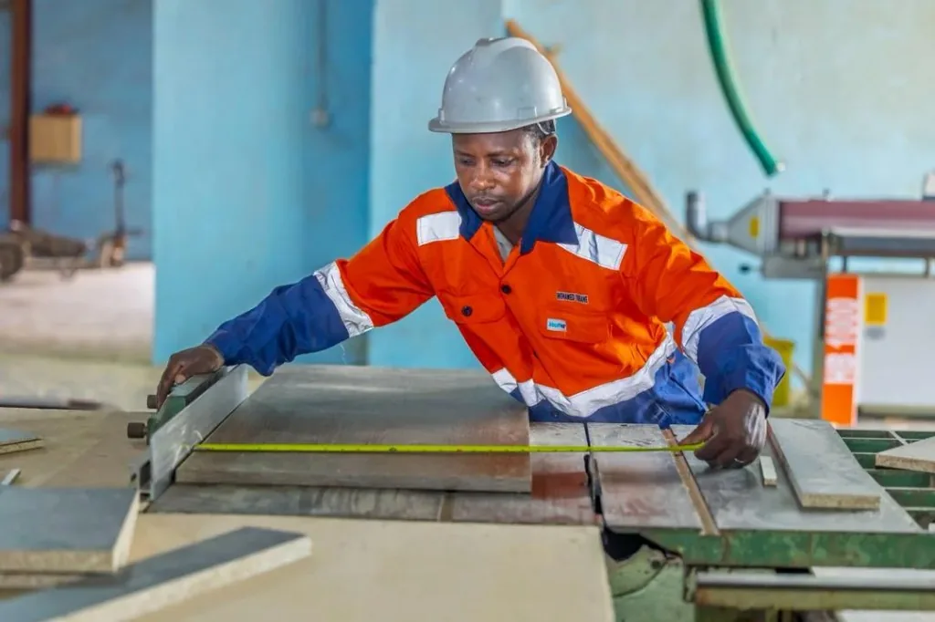 Ouvrier ARREDA en pleine mesure sur machine de coupe
